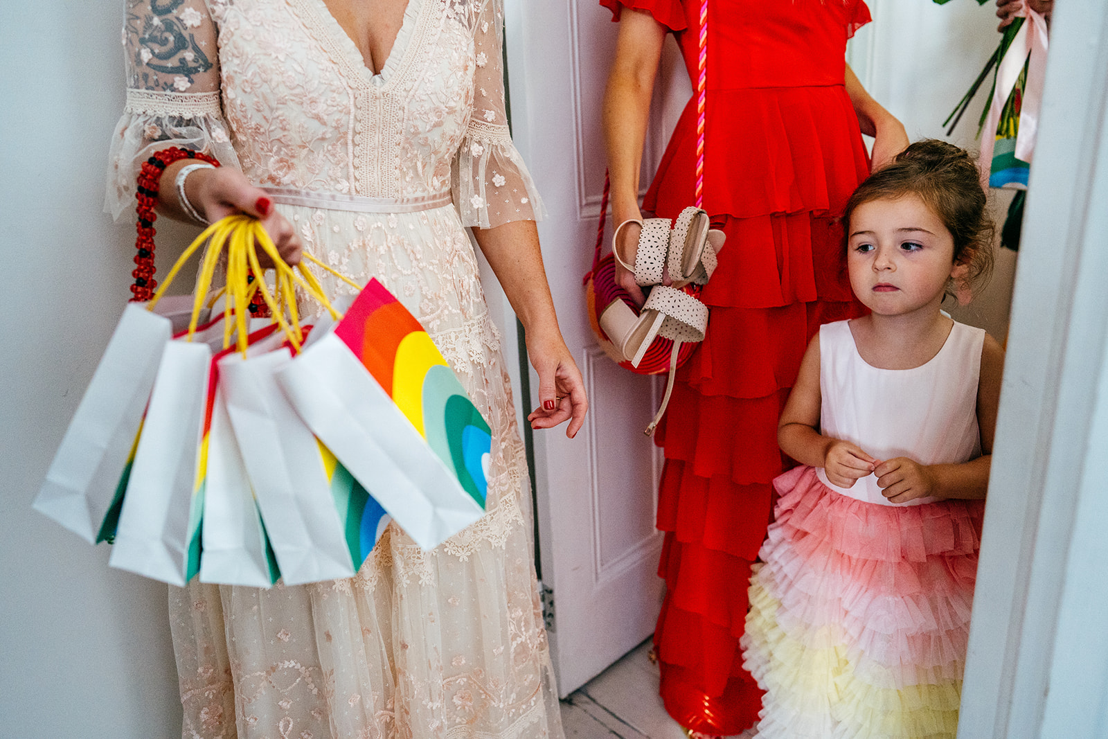 Flower girl looks longingly on at rainbow gift bags