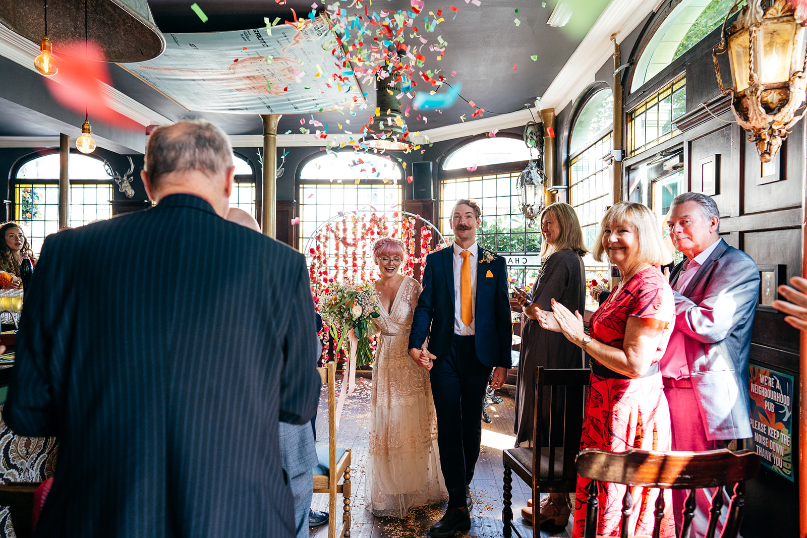 Bride and groom exit London Pub Wedding with Confetti Canons in the background