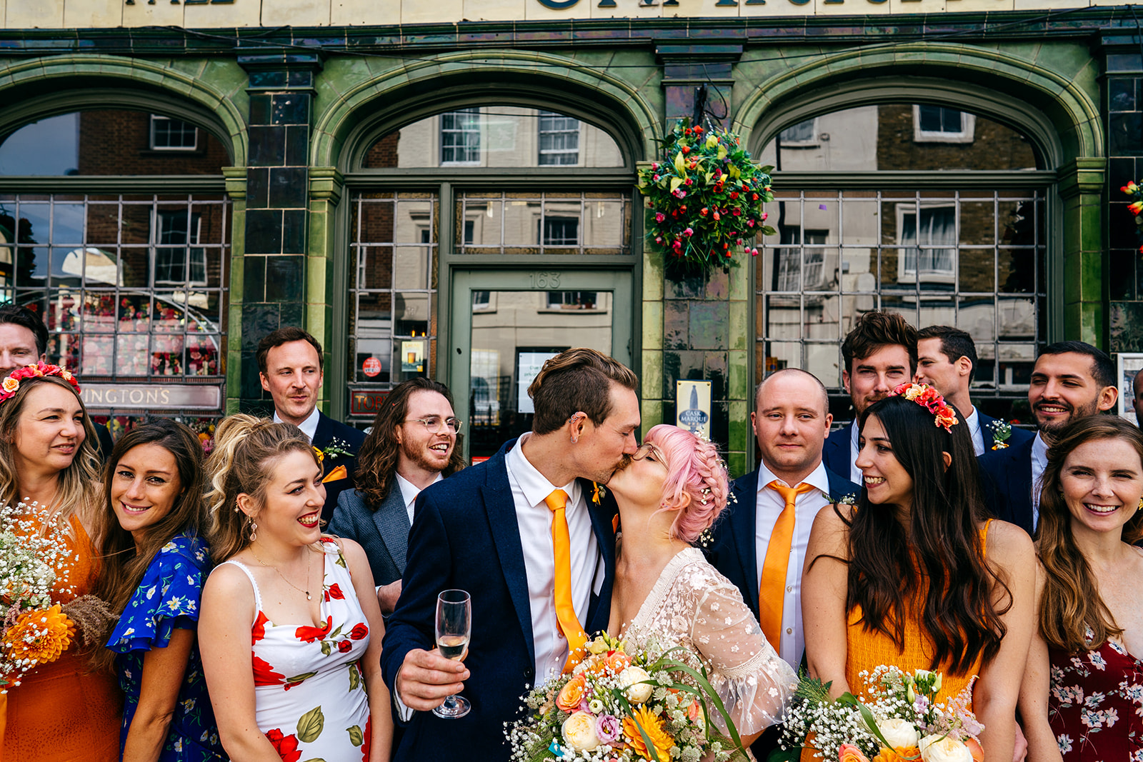 Couple kiss outside their London pub wedding surrounded by guests