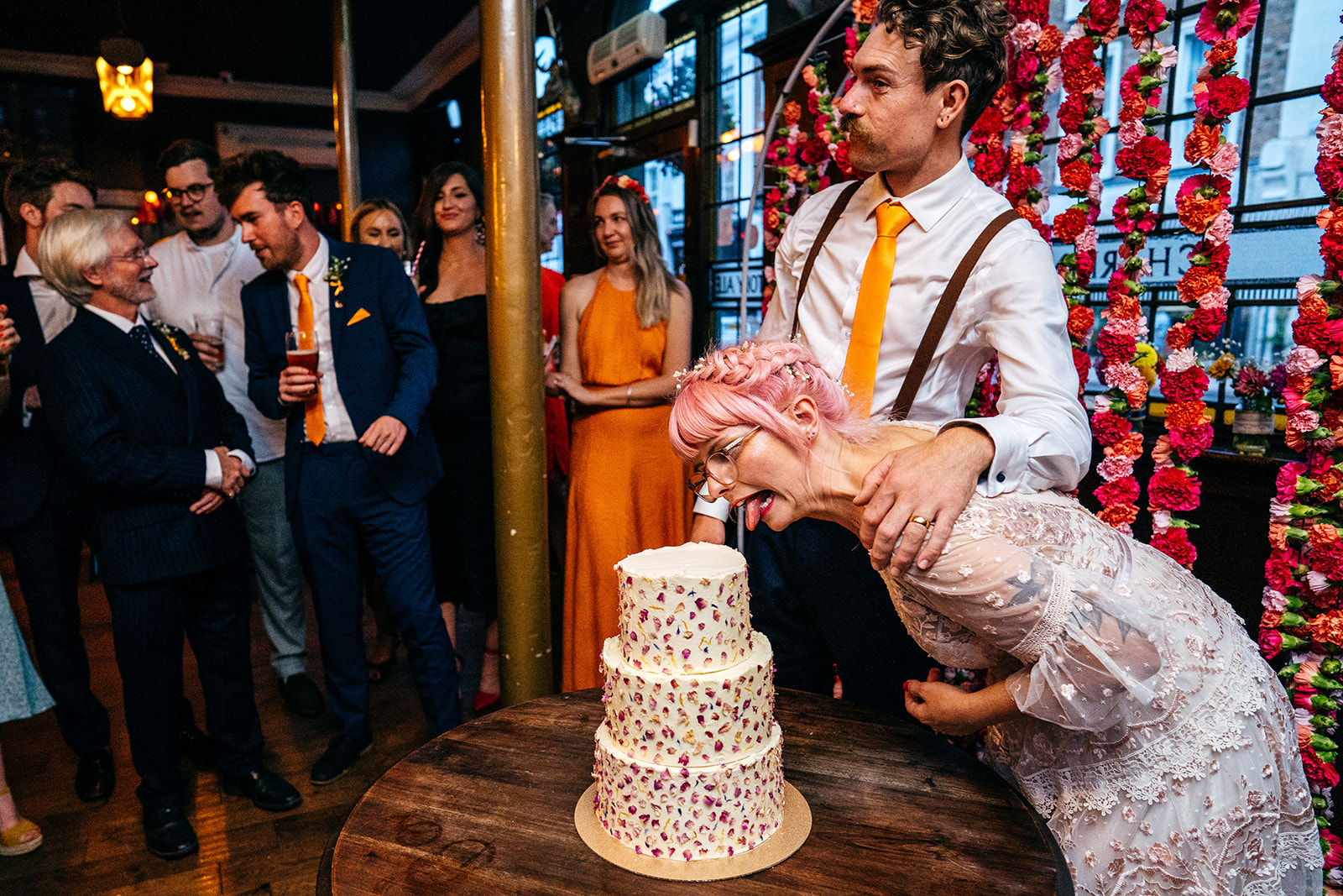 Bride licks wedding cake 