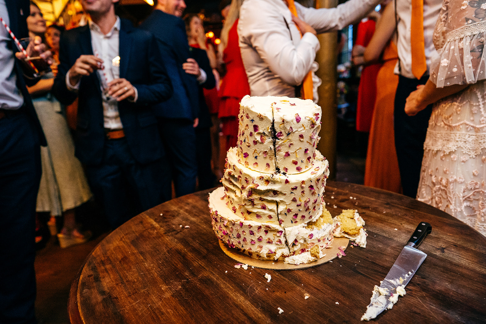 Squashed and fingered wedding cake and cake knife on table at London Wedding