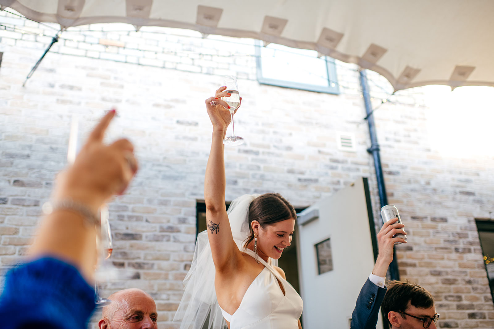 Bride raises a glass during her own wedding speech toasting the room at London wedding