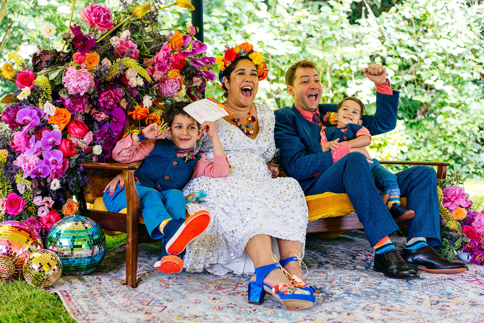Family whoop during child focussed wedding ceremony sat on gorgeous velvet sofa