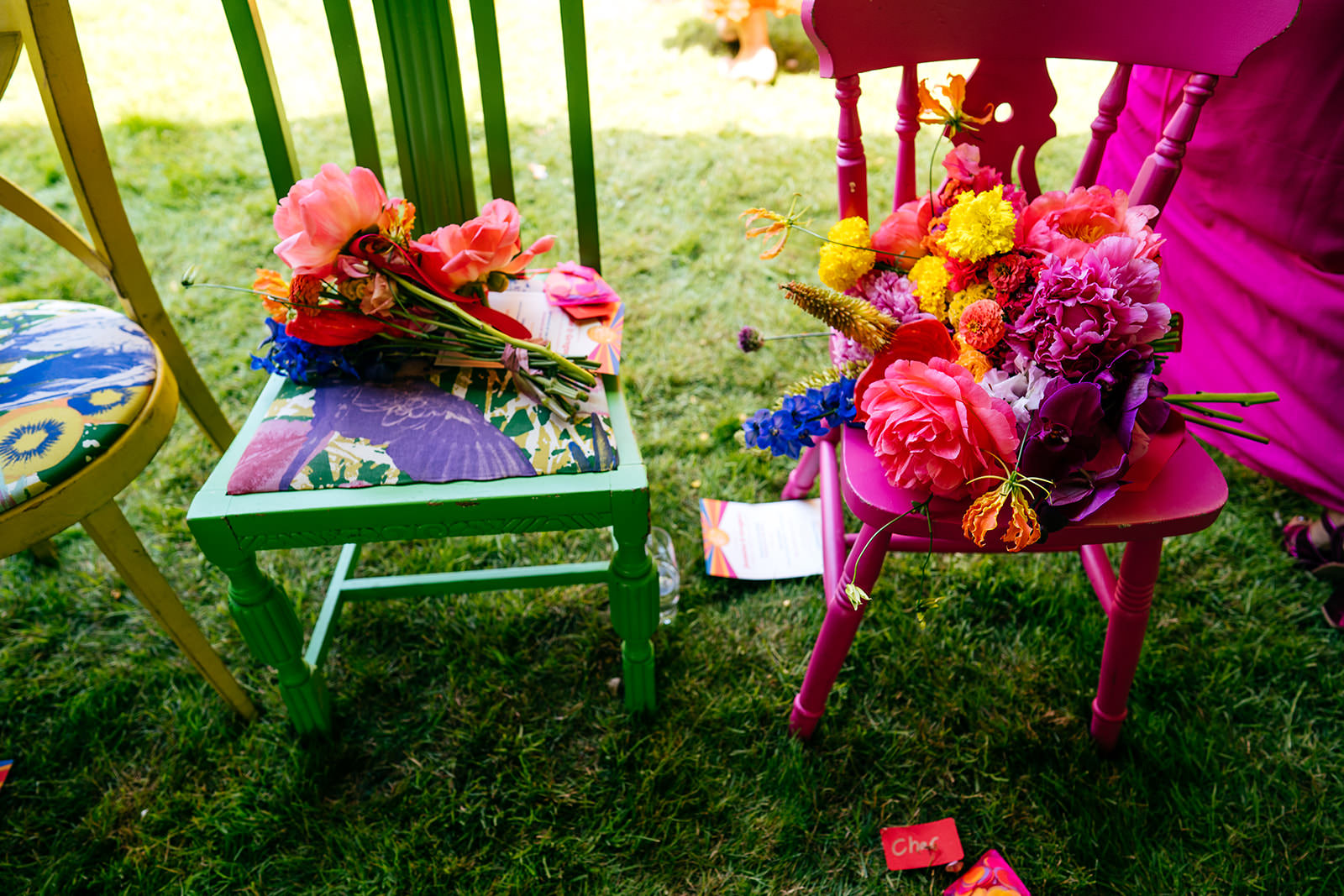 Bridesmaid bouquets on colourful ceremony chairs 