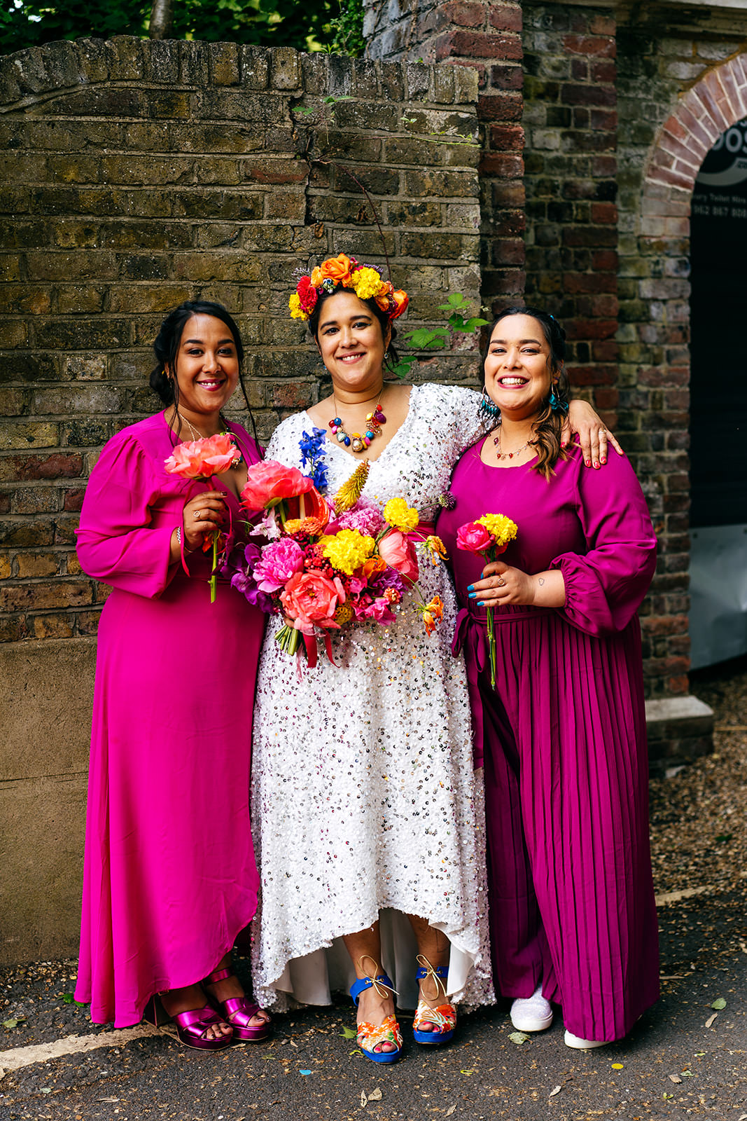 Bride and her sisters in hot fuschia dressses and flower crown 