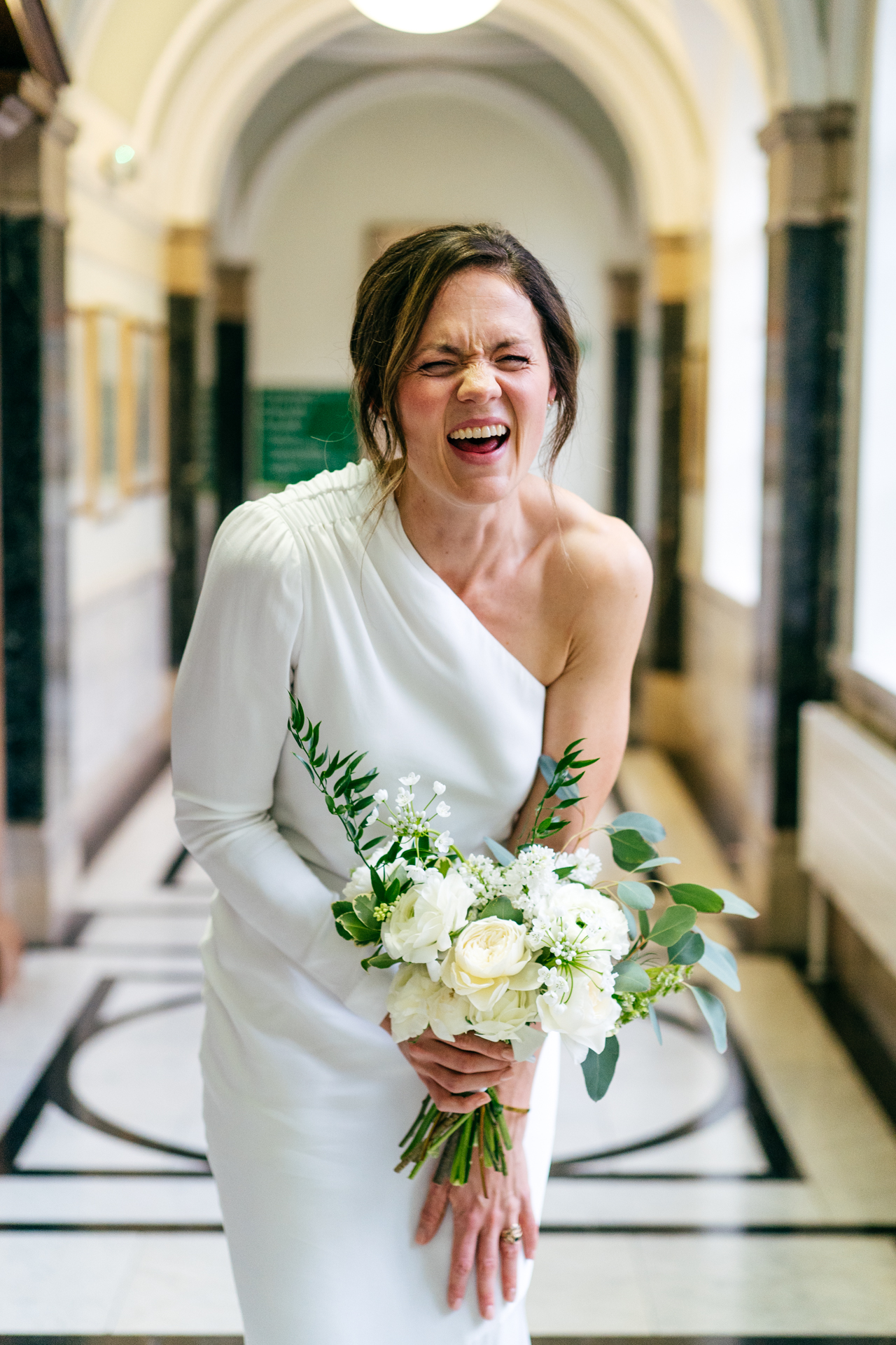 Bride laughing in corridor of Islington Town Hall 