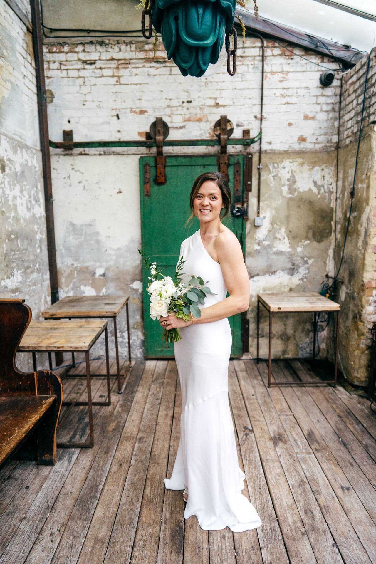 Simple portrait of bride holding her bouquet outside Clapton Country Club