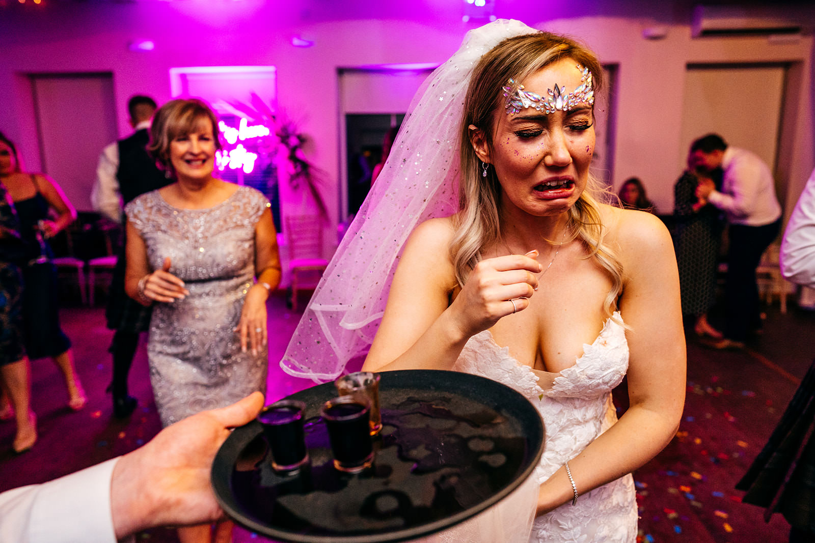 Bride does a shot pulls a funny disgusted face 