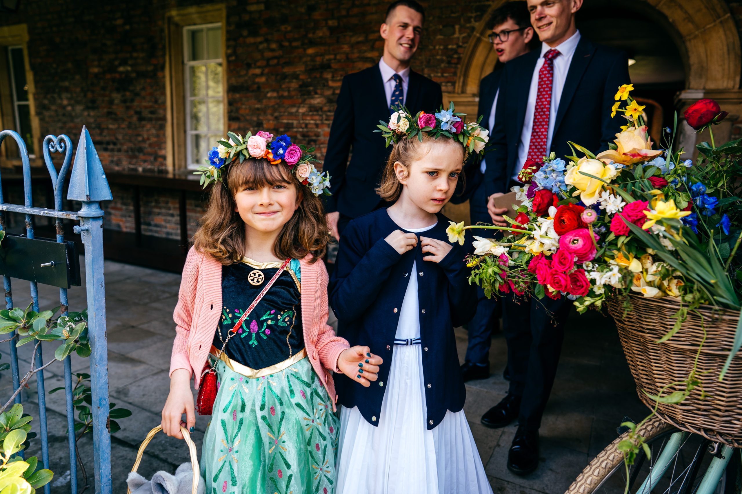 Flower girls near flower bike entering Cloister Court Gardens at Sidney Sussex College Wedding